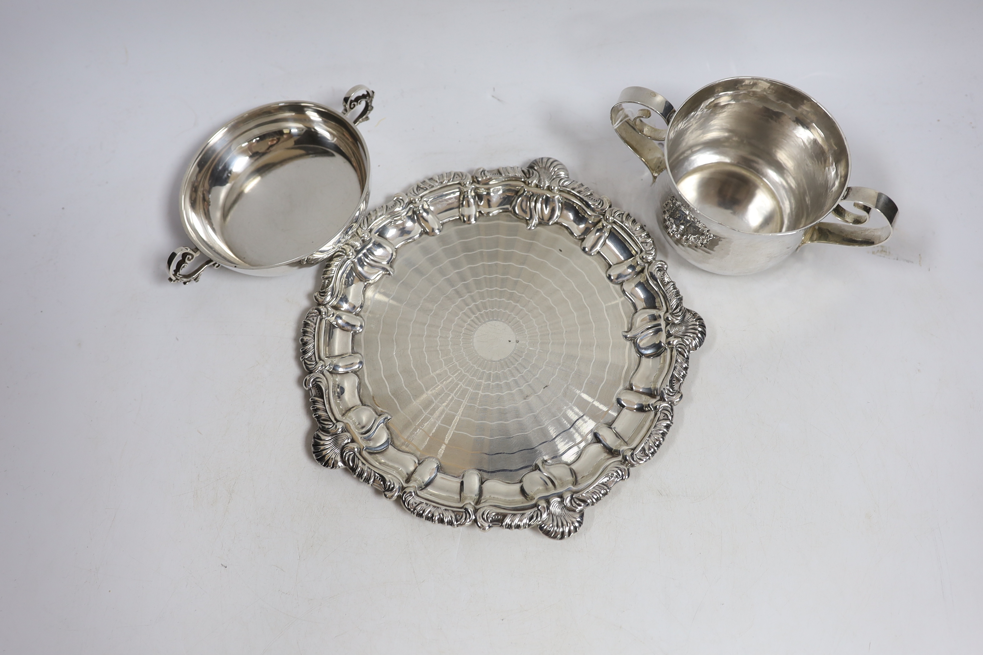 An Edwardian planished Britannia standard silver two handled cup, by Daniel & John Welby, London, 1902, height 77mm, together with a silver shallow two handled dish, a pierced silver oval dish and a silver waiter, 24.4oz